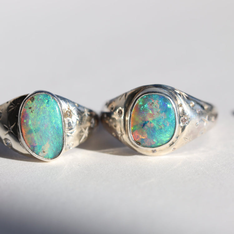 Two silver rings with opal stones on a white background